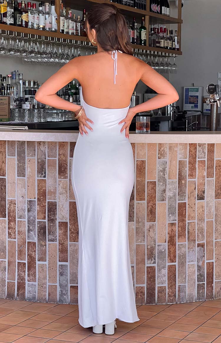 Rear view of a white maxi dress with a backless design and halter neck tie