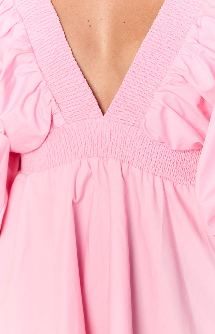 Close-up of the pink dress showing the smocked V-neckline and elasticated smocked waist detail
