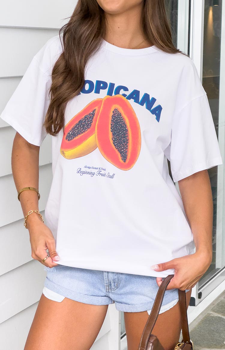 White oversized tee with a large graphic print of two orange papaya halves and blue TROPICANA text
