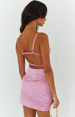 Rear view of a pink satin mini dress with thin adjustable straps and an open back featuring two elasticated bands