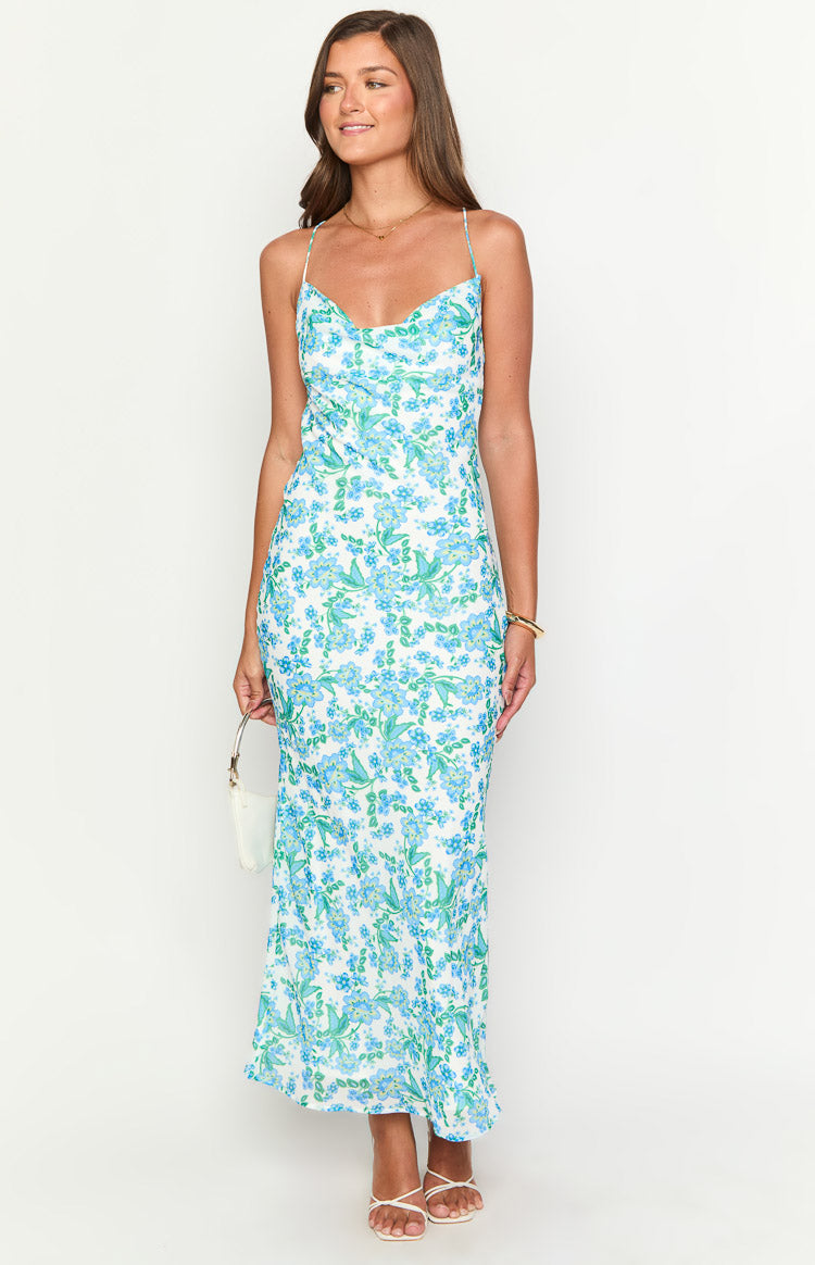 White floral maxi dress with blue and green print, a draped cowl neckline, and thin spaghetti straps