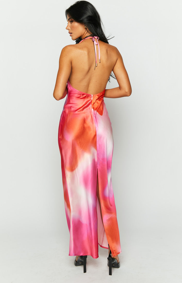 Rear view of a pink print halter neck maxi dress with an open back, visible back zipper, and a high side slit