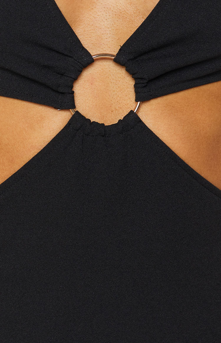 Black textured dress with a gold O-ring detail connecting gathered fabric panels and chest cutouts
