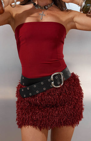 Close up of a wide black leather belt with silver eyelets a perfect edgy accessory for a Festival outfit