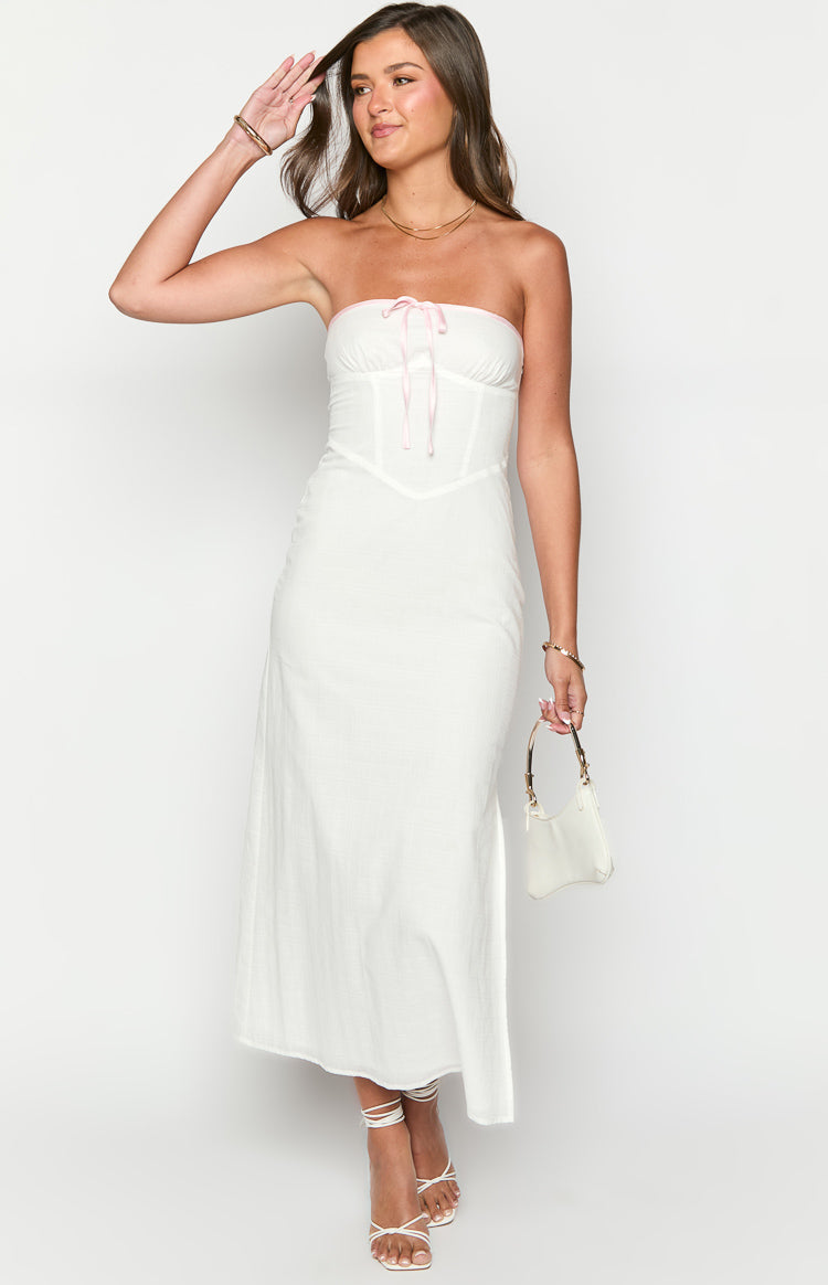 White strapless maxi dress with a pink ribbon tie at the bust and corset-style seaming on the bodice