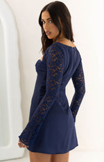Side view of a navy mini dress showing the sheer floral lace long sleeves and fitted bodice