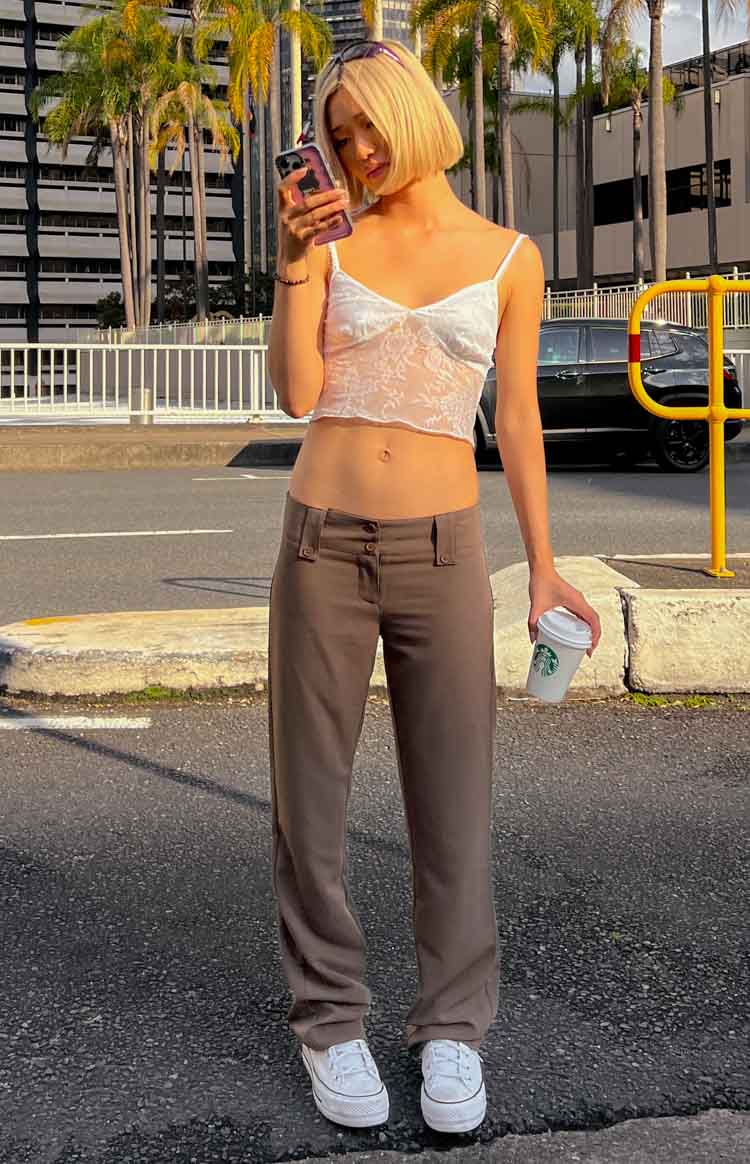 Front view of taupe low waist pants with a double button closure and small flap details
