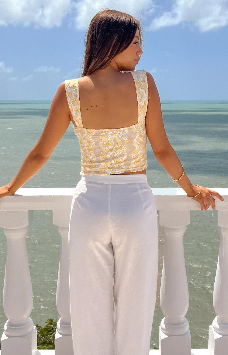 Close-up of the yellow lace bow top showing the ruched bodice and cream bow details on the straps