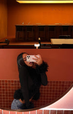Side view of a black ribbed knit cardigan with shaggy fur trim on the cuffs and hem