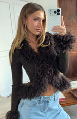 Close-up of the chocolate brown ribbed knit cardigan with shaggy fur trim along the V-neckline and cuffs
