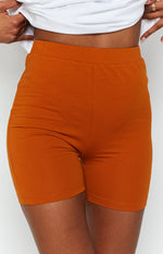 Tan high-waisted jersey shorts with an elastic waistband and short length