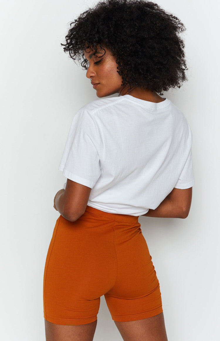 Tan jersey knit shorts with a form-fitting design and wide elastic waistband