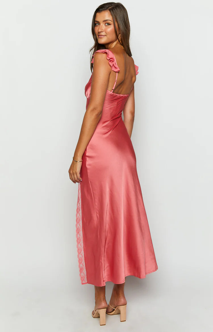 Side view of a coral pink satin maxi dress with ruffled shoulder straps and a lace insert panel