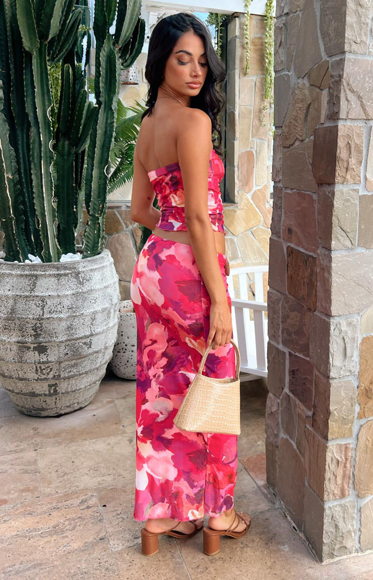 Side view of a fitted pink abstract print mesh maxi skirt, showing its full length and sheer fabric