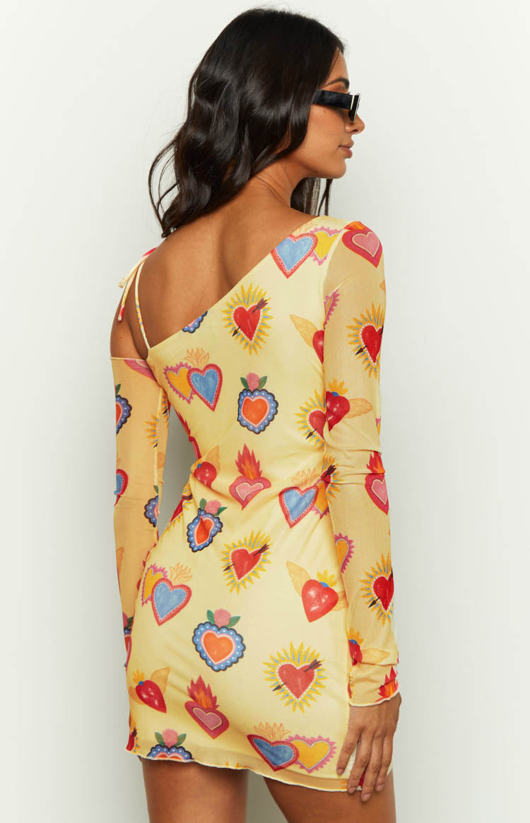 Rear view of the yellow mesh mini dress showing the one-shoulder design with a thin strap and long sleeve