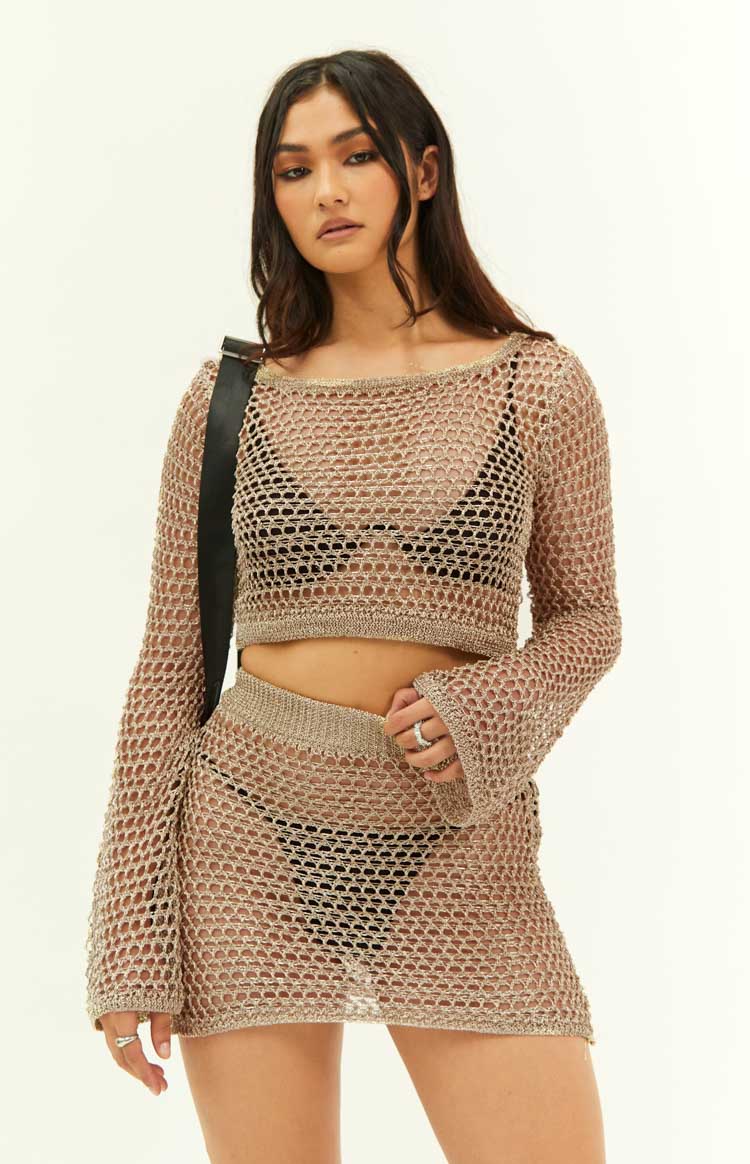 Close-up of the gold metallic fishnet mini skirt, highlighting its sheer open knit and metallic shimmer