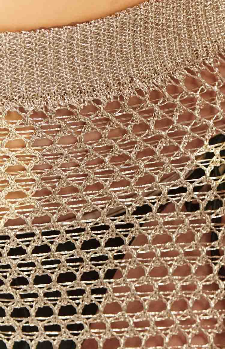 Close-up of the gold metallic fishnet skirt fabric showing the ribbed waistband and open diamond pattern