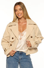 Beginning Boutique Wilda Cream Cropped Trench Coat cream double-breasted cropped trench coat with wide lapels epaulets and buckled cuffs