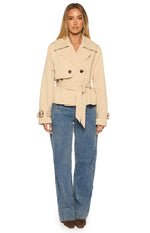 Front view of a cream cropped trench coat with wide lapels, double-breasted front, and a self-tie waist belt