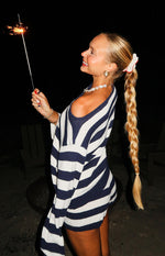 Side view of navy stripe knit shorts with a relaxed fit, partially visible beneath a matching oversized knit top