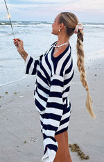 Side view of a navy and white striped off-shoulder knit sweater with a relaxed fit and long sleeves