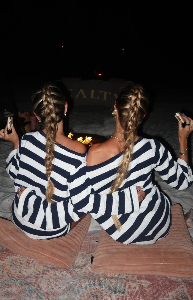 Rear view of a navy and white stripe knit sweater with an off-shoulder neckline and long sleeves