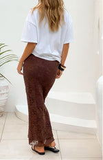 Rear view of a brown lace midi skirt with a fitted silhouette and slight flare at the hem