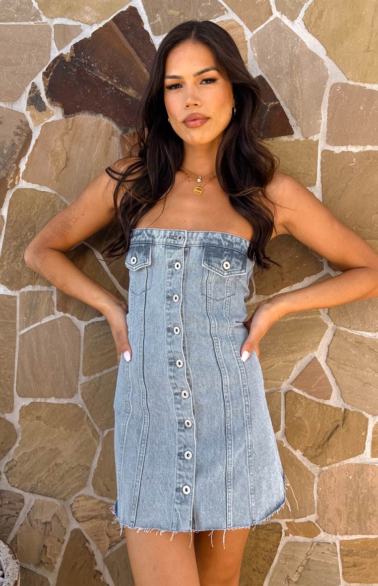 Blue denim strapless mini dress with a full button-front, bust pockets, and frayed hem