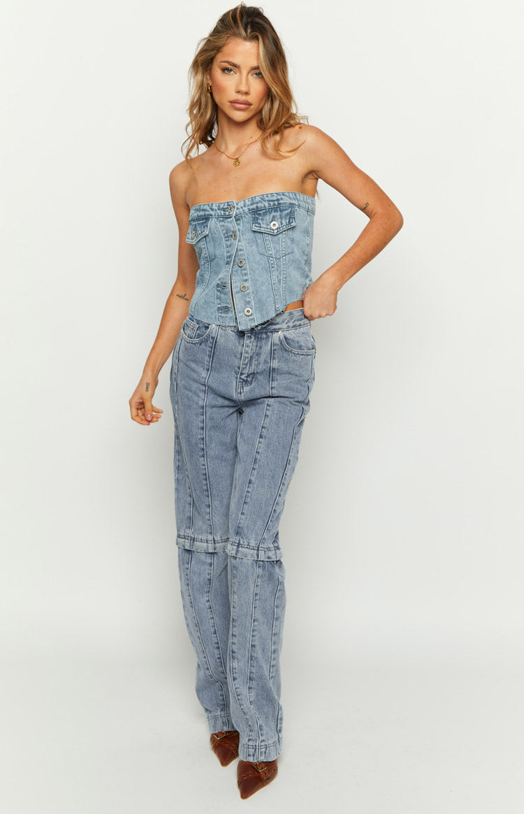 Front view of a mid-wash denim strapless button-front top with chest pockets and a curved hem