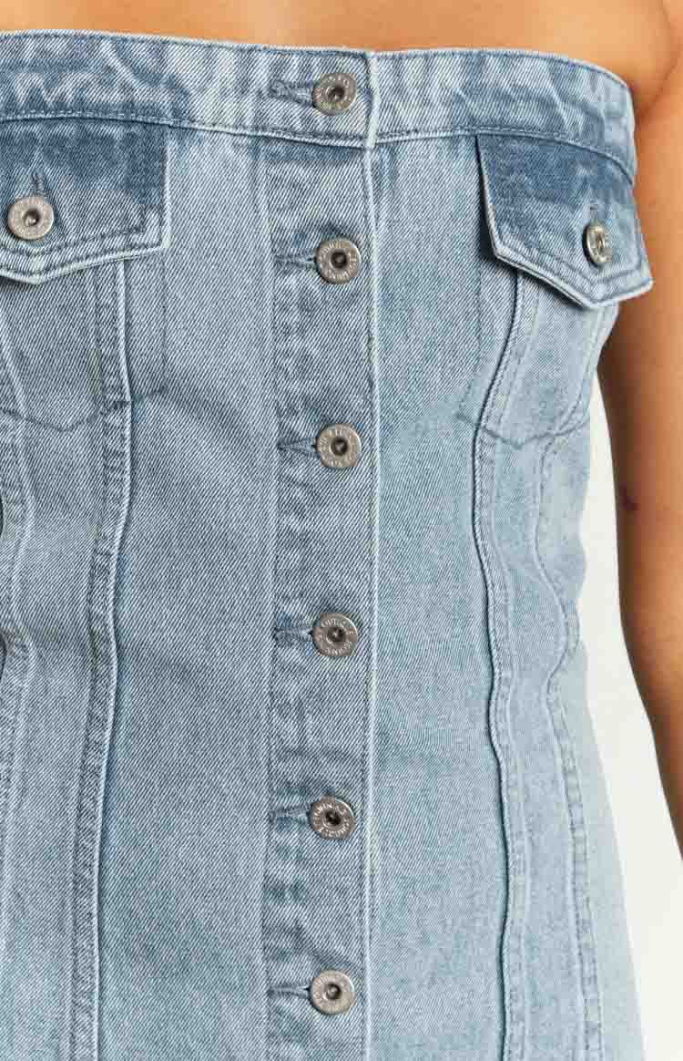 Front close-up of the light blue denim mini dress with silver button-front closure and two chest flap pockets
