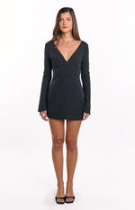 Black polka dot mini dress featuring a deep V-neck and long fitted sleeves