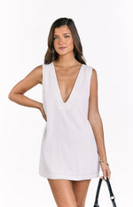 Front view of a white linen sleeveless shift mini dress with a deep V-neckline and panel detail