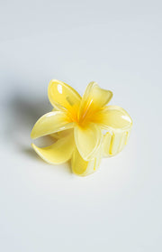 Side view of a translucent yellow frangipani flower claw clip with a brighter yellow centre