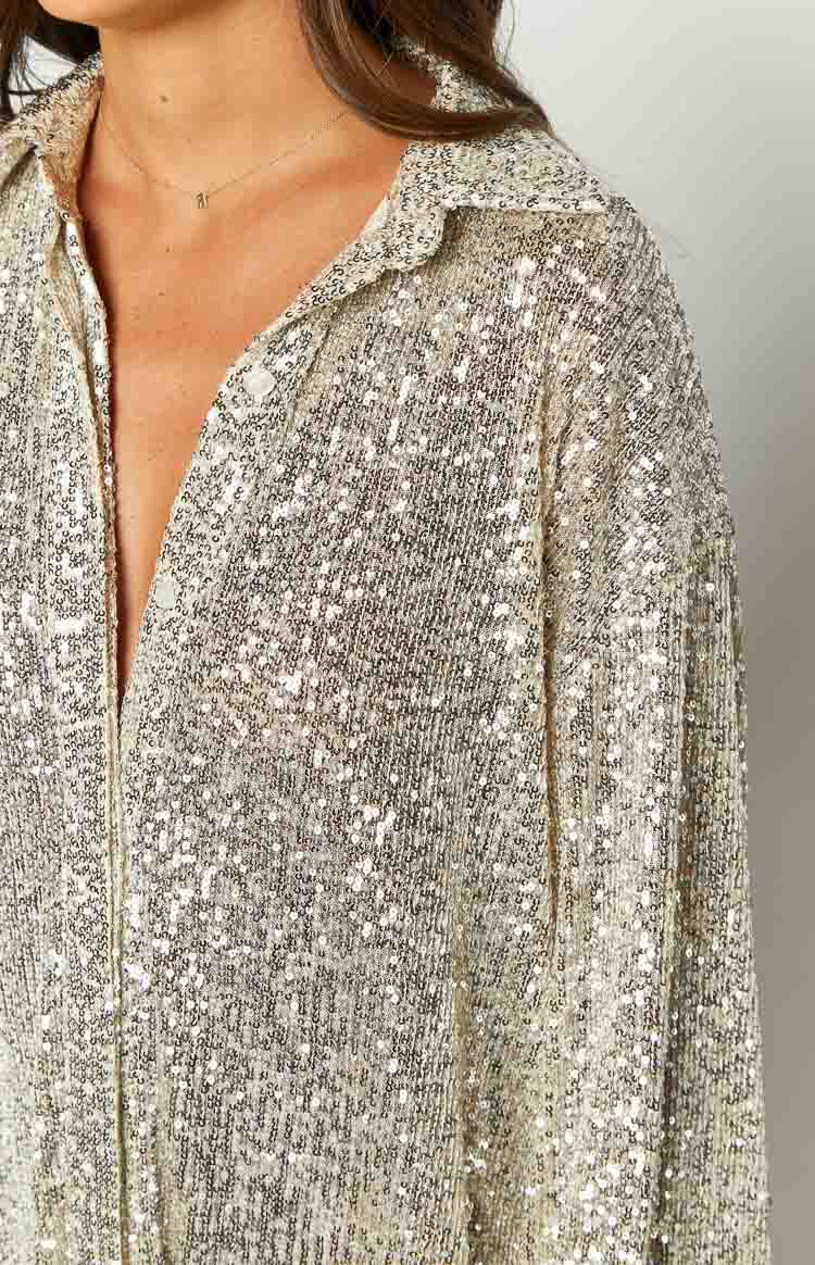 Full front view of an oversized gold sequin long sleeve shirt with a deep V-neck, collared neckline, and buttoned cuffs