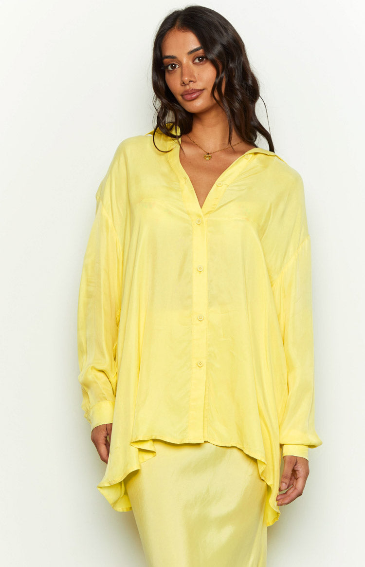 Front view of a yellow cupro button-up shirt worn open, showing its relaxed fit and soft drape