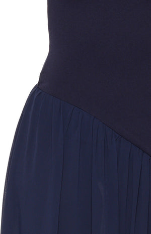 Close-up of the navy maxi dress showing the diagonal seam where the fitted bodice joins the gathered skirt