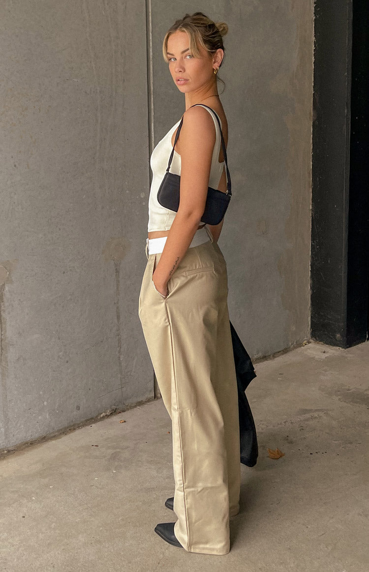 Side view of tan high-waisted wide-leg pants with a relaxed fit and side pockets