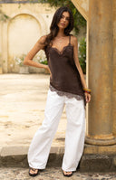 Close-up of the brown satin top showing the delicate lace trim along the asymmetrical hemline