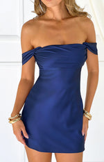 Close-up of the navy off-the-shoulder mini dress showing the twisted neckline and smooth satin fabric