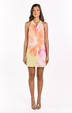 Front view of a yellow mini dress with a vibrant orange and pink hibiscus floral print and cowl halter neckline