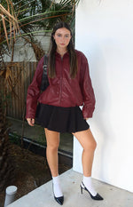 Relaxed fit red PU bomber jacket with a collared neckline, zip front, and elasticated hem