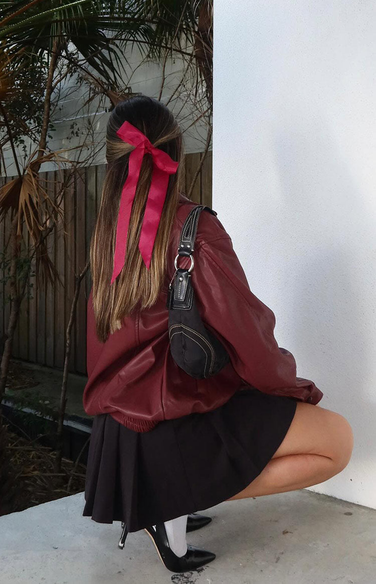 Side view of a red PU bomber jacket showing the oversized fit, long sleeves, and elasticated hem