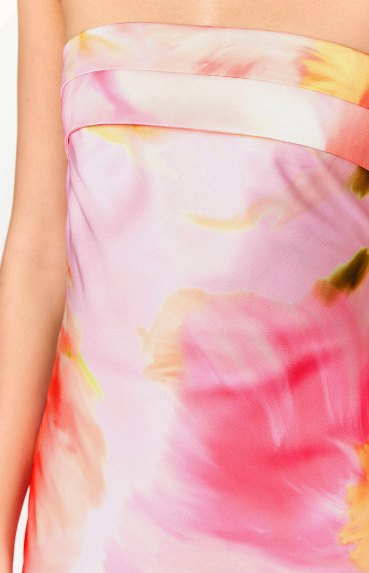 Close-up of the strapless bodice with a horizontal band detail and blurred pink, yellow, and green floral print