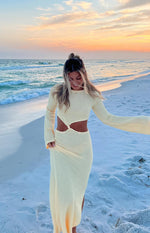 Yellow knit maxi dress with long bell sleeves, round neck, and front waist cutouts with knot detail