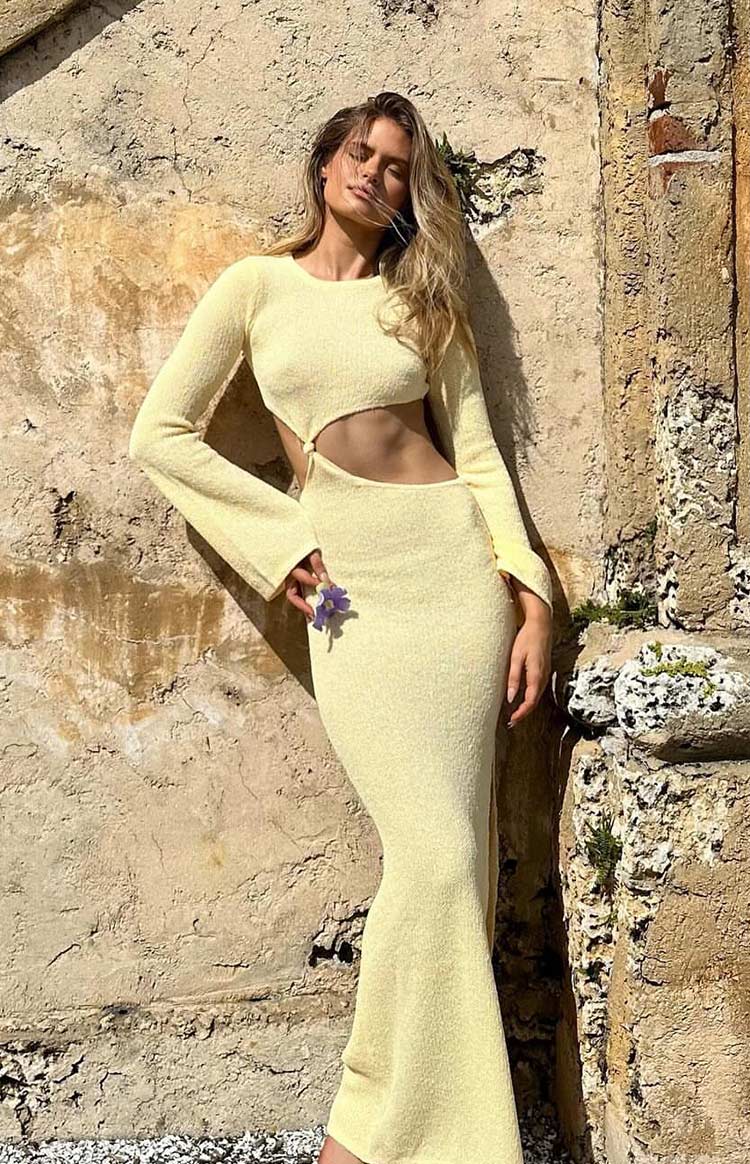 Yellow knit maxi dress with long bell sleeves, round neck, and front waist cutouts with knot detail