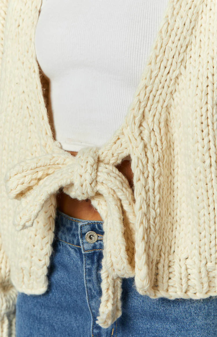 Rear view of a cream knit cardigan with a tie-up back detail and relaxed long sleeves