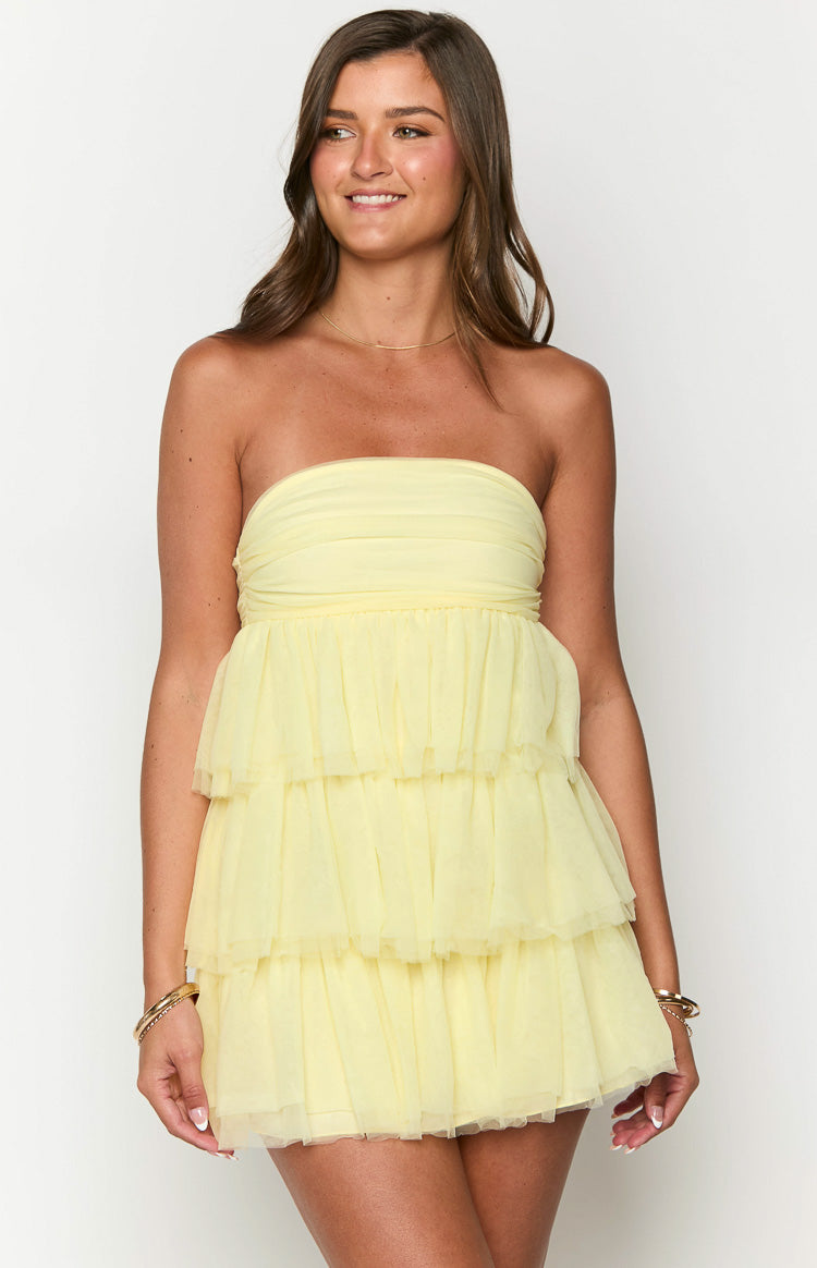 Front view of a light yellow strapless mini dress with a tiered ruffled skirt