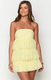 Front view of a light yellow strapless mini dress with a tiered ruffled skirt