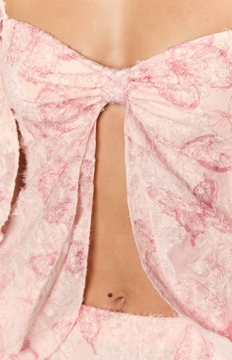 Close-up of the pink chiffon top's front bow detail, central cutout, and textured butterfly pattern