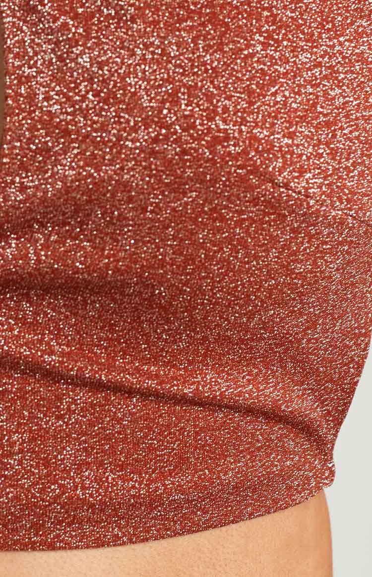 Close-up of the copper glitter knit fabric of the mini skirt